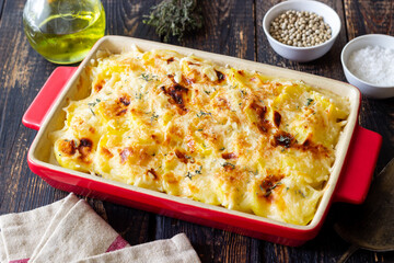 Potato casserole with cheese and cream. Vegetarian food. French food. Gratin dauphinois. - obrazy, fototapety, plakaty