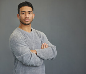 Serious portrait of man in studio with mockup, arms crossed and model on studio backdrop in casual fashion. Relax, confidence and face of male on grey background with focus, pride and mock up space.