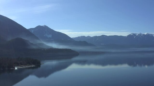 Reflective Whispers: Capturing Smoke's Mystique on Slocan Lake's Mirrored Surface