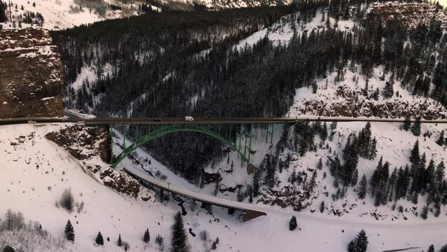 Aerial view of white camper van crossing Red Cliff Steel Arch Bridge