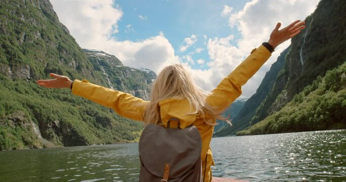 Boat travel, nature and back of a woman with freedom for vacation, transport and adventure. Free, happy and a female tourist on the water on the lake with mountains for holiday, happiness and a break