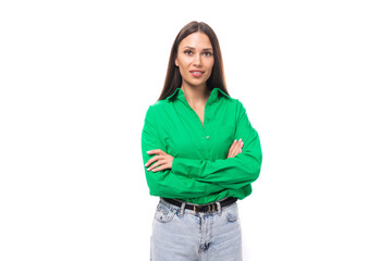 pretty young caucasian brunette lady with makeup dressed in a green shirt and jeans posing on a white background with copy space