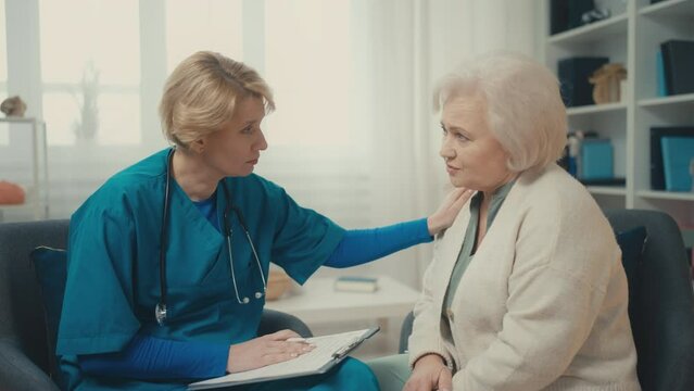 Serious doctor telling bad news about disease, visiting elderly woman at home