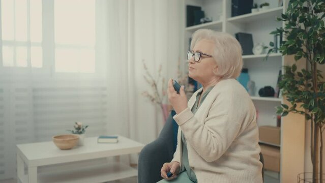 Senior woman using inhaler home, taking medication for asthma attack treatment