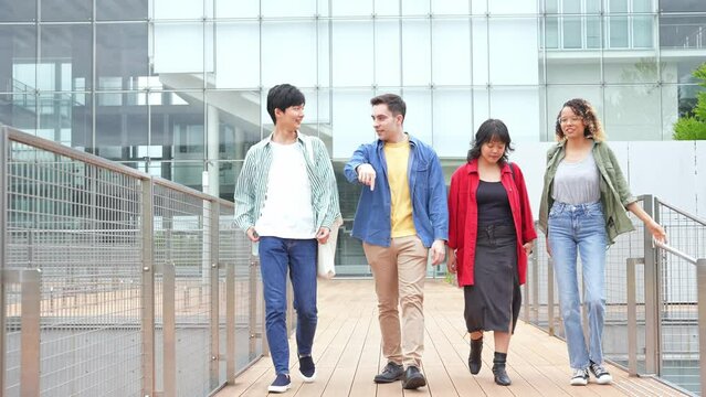 Multinational youth group walking in college campus. College students.