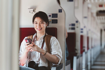 Asian Tourist person backpacker to travel at train station and using mobile phone. Tourism and...