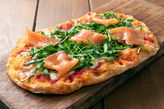 Deliziosa pinsa romana condita con salmone affumicato e rucola, cibo italiano 