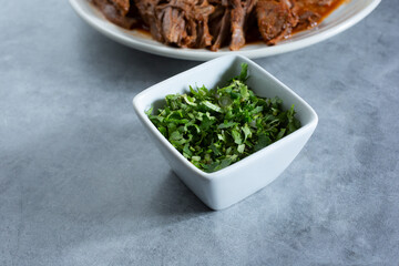 A view of a condiment cup of chopped cilantro.