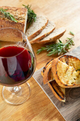 A view of a platter of toast and a glass of red wine.