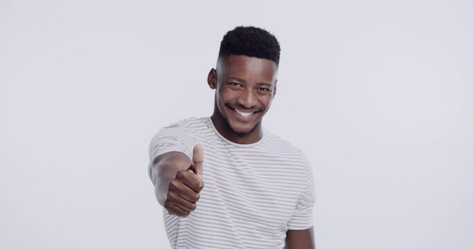 Happy, thumbs up and face of black man in studio isolated on a white background. Portrait, like hand gesture and African male person with emoji for agreement, success or review, vote and mockup goal.