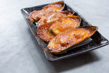 A view of a plate of baked green mussels.