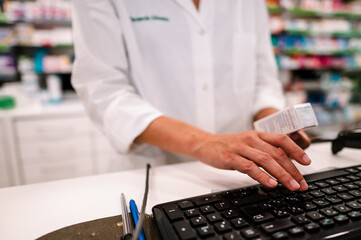 Woman at the checkout in a pharmacy to sell a drug