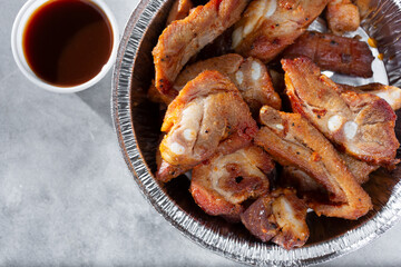 A top down view of a container of deep fried pork rib tips.