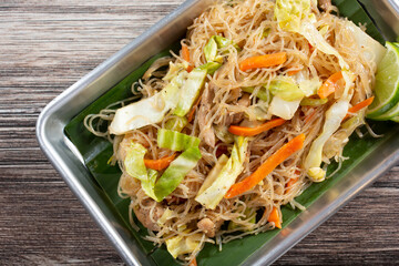 A top down view of a tray of pancit.