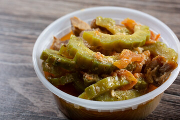 A closeup view of a plastic container of ginisang ampalaya.