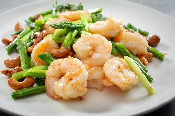 Fototapeta na wymiar A view of a plate of stir fried shrimp and asparagus.