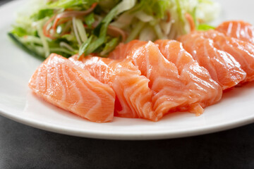A closeup view of a plate of farmed Atlantic salmon sashimi.
