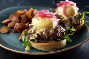 A closeup view of a plate of braised beef eggs Benedict.
