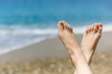 Vacation holidays. Woman feet closeup of girl relaxing on beach on sunbed enjoying sun on sunny summer day.