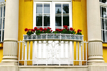 white steel picket balustrade of old French balcony. yellow stucco exterior elevation detail....