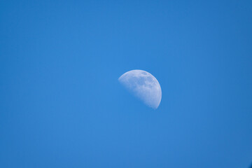 half moon against blue sky closeup