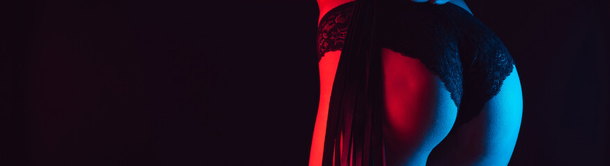 Sexy big ass girl in Lacy black panties with leather whip. BDSM toys for role-playing games for domination. Panoramic wide horizontal photo for banner head cover