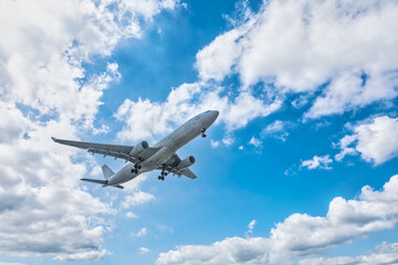 Fototapeta na wymiar Commercial airplane flying in blue sky