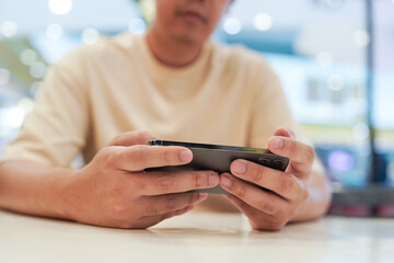 Man playing game on mobile phone. gamer boy playing video games holding Smartphone working mobile devices. cell telephone technology e-commerce concept