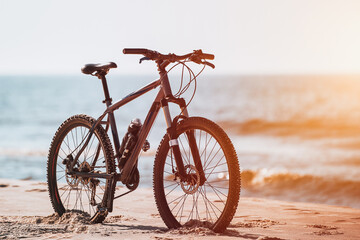 Obraz premium Bike on the Baltic Sea seashore sandy beach. Fitness sports motivation and inspiration. MTB on the seaside