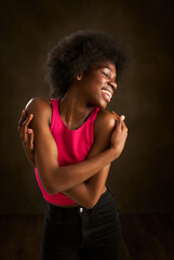 Fototapeta na wymiar a young black woman with afro hair and a big smile embraces with happiness