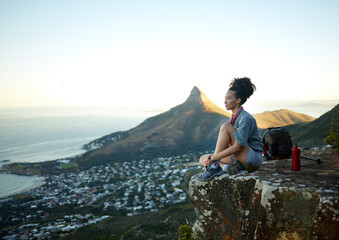 Obraz premium Woman, mountain and sitting with view of cityscape outdoor for exercise in Cape Town. Female hiking, cliff and South Africa for adventure in nature in the morning for wellness on the weekend.