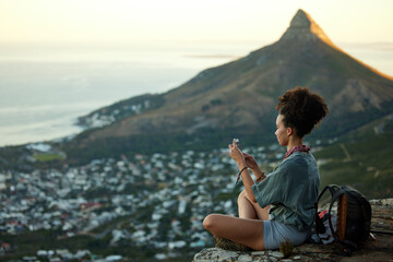 Woman, hiking and phone on mountain for travel in cape town for wellness on the weekend. Female...