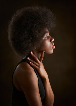 Profile portrait of a beautiful young black woman is serious and has curly black afro hair