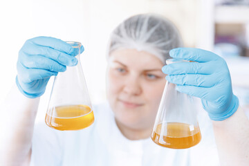 Laboratory assistant inspecting production beer, analysis drink in glasses. Concept brewery food industry