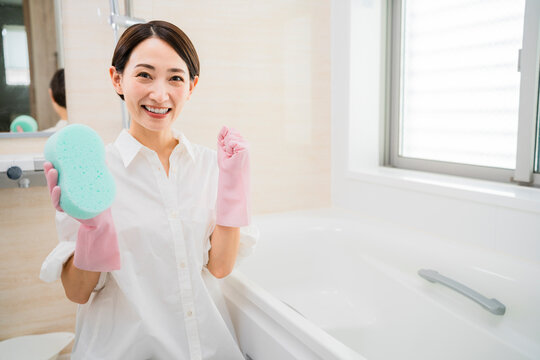 お風呂の浴槽を洗う若い女性　ライフスタイルイメージ