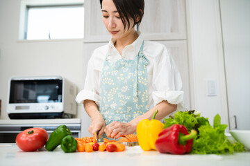 野菜を切る若い女性　料理イメージ