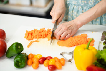 野菜を切る若い女性　料理イメージ