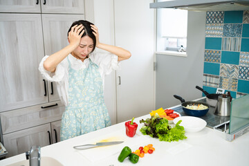 頭を手で覆う若い女性　料理イメージ