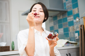 サクランボを食べる若い女性　飲食イメージ