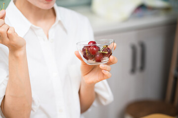 サクランボを食べる若い女性　飲食イメージ