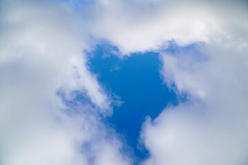 A hole in the white clouds, which is visible the blue sky. Soft focus
