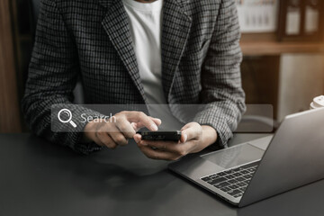 Male businessman clicking internet search page on computer and smart phone touch screen in the office.