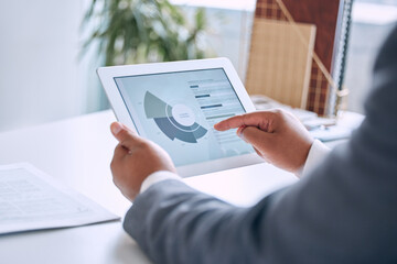 Hands typing, tablet and chart in office for social media marketing, stats or analysis on software....
