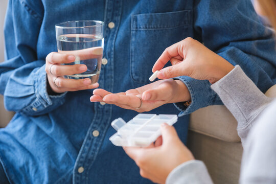 Closeup image of a woman holding and giving pills to her friend