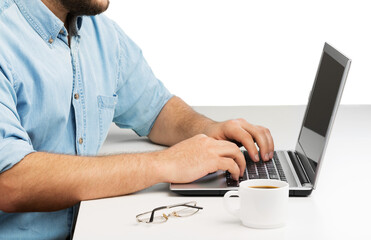 Worker man using a laptop while sitting the wooden table.