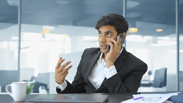 Indian manager talking to employee on phone