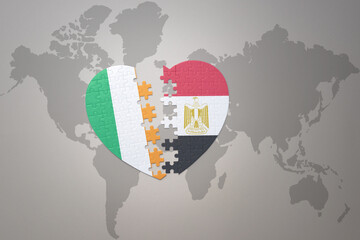puzzle heart with the national flag of egypt and ireland on a world map background.Concept.
