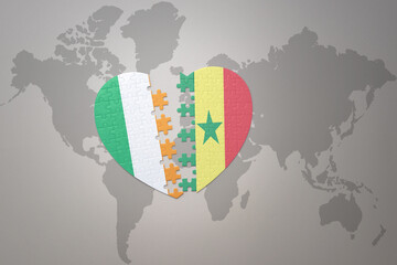 puzzle heart with the national flag of senegal and ireland on a world map background.Concept.