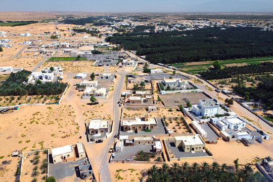 Aerial view of the city Falaj al Mashayikh on sunny day. City on the edge of the desert. Sultanate of Oman