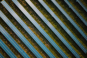 Solar panel rows aerial view. Photovoltaic panels farm from the sky, diagonal rows for renewable solar energy. Reducing carbon footprint concept, clean green energy for the future.